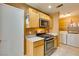 Kitchen featuring wood cabinets, stainless steel oven and microwave, and access to the laundry room at , Las Vegas, NV 89145