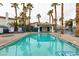 Community pool surrounded by palm trees and a blue safety fence at , Las Vegas, NV 89145