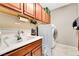 Well-equipped laundry room with a sink, cabinets, and a modern washer and dryer, providing convenience at 10247 Jamapa Dr, Las Vegas, NV 89178