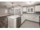 Stylish kitchen featuring white cabinets, marble countertops, stainless steel appliances, and modern light fixture at 10291 Delta View Ct # 101, Las Vegas, NV 89129