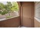 Covered patio door with lantern fixture and stucco wall with mature tree view at 10291 Delta View Ct # 101, Las Vegas, NV 89129