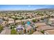 Aerial view of a neighborhood highlighting this home with solar panels near mountains and city at 10680 Sapphire Vista Ave, Las Vegas, NV 89144