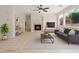 Comfortable living room featuring a cozy fireplace, neutral decor, and large windows for natural light at 10680 Sapphire Vista Ave, Las Vegas, NV 89144