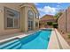 Backyard pool and spa featuring stone accents, lush greenery, and a spacious patio for outdoor entertaining at 10680 Sapphire Vista Ave, Las Vegas, NV 89144