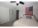 Bright bedroom with comfortable bed, ceiling fan, flag wall decor, and interior door to another room at 109 Ash St, Henderson, NV 89015