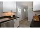 Well-lit kitchen with white cabinets, black countertops, and stainless steel dishwasher at 109 Ash St, Henderson, NV 89015