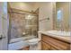 Neutral bathroom featuring a tub/shower combo, vanity and travertine tile surround at 12021 La Palmera Ave, Las Vegas, NV 89138