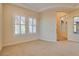 Spacious bedroom with plantation shutters, neutral carpet, and a view into the arched entry hallway at 12021 La Palmera Ave, Las Vegas, NV 89138