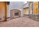 View of the stone-tiled courtyard with a stone fireplace, offering a private and relaxing outdoor space at 12021 La Palmera Ave, Las Vegas, NV 89138