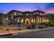 Charming two-story home with desert landscaping, circular stone entry, and a tile roof at dusk at 12021 La Palmera Ave, Las Vegas, NV 89138