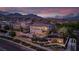 Beautifully landscaped property with a pool and spa, set against a mountain backdrop at sunset at 12021 La Palmera Ave, Las Vegas, NV 89138
