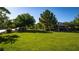Inviting view of a neighborhood green space featuring mature trees, a covered picnic area, and lush lawn at 12021 La Palmera Ave, Las Vegas, NV 89138