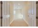 Hallway with neutral walls and carpet, and the view of a room with a shuttered window at 12021 La Palmera Ave, Las Vegas, NV 89138