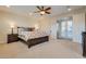 Bright main bedroom features a decorative ceiling fan, and doors to an outdoor balcony at 12021 La Palmera Ave, Las Vegas, NV 89138