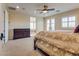 Bright main bedroom featuring neutral carpet, a ceiling fan, and a view into the primary bath at 12021 La Palmera Ave, Las Vegas, NV 89138