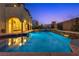 Inviting backyard pool and spa with tiered waterfalls and beautiful landscaping at twilight at 12021 La Palmera Ave, Las Vegas, NV 89138