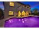Luxury backyard pool with hot tub, covered patio, arches, and an upstairs balcony at twilight at 12021 La Palmera Ave, Las Vegas, NV 89138