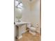 Charming powder room featuring a pedestal sink, travertine floors and classic fixtures at 12021 La Palmera Ave, Las Vegas, NV 89138