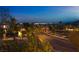 Scenic street view showcasing lush landscaping, mature trees, and a glimpse of the city skyline at 12021 La Palmera Ave, Las Vegas, NV 89138