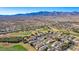 A wide aerial view showcases a residential area nestled next to a golf course, surrounded by desert and mountain landscape at 1441 Palm Dr, Laughlin, NV 89029