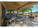 Covered back patio with ceiling fan, dining furniture, and a fountain, perfect for outdoor entertaining at 1441 Palm Dr, Laughlin, NV 89029