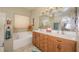 Bathroom features double sinks, and a soaking tub with tile flooring at 1441 Palm Dr, Laughlin, NV 89029