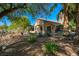 Well-maintained backyard features a covered patio with an outdoor dining area and lush desert landscaping at 1441 Palm Dr, Laughlin, NV 89029