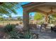 Covered patio with dining seating, ceiling fan, and lush greenery with mountain views at 1441 Palm Dr, Laughlin, NV 89029
