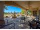 Spacious covered patio with ceiling fan and comfortable seating overlooking lush landscaping at 1441 Palm Dr, Laughlin, NV 89029