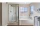 Modern bathroom features a walk-in shower, soaking tub, and frosted windows for privacy at 1512 Groom Ave, North Las Vegas, NV 89081
