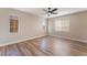 Light bedroom features wood-look flooring, neutral paint, ceiling fan, and three windows at 1512 Groom Ave, North Las Vegas, NV 89081