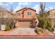 Inviting two-story home features a terracotta facade, well-kept landscaping, and attached two-car garage at 1512 Groom Ave, North Las Vegas, NV 89081