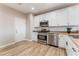 Well-lit kitchen featuring stainless steel appliances, granite countertops, and white cabinets at 1512 Groom Ave, North Las Vegas, NV 89081