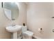 This updated powder room features a pedestal sink, round mirror, and sleek fixtures at 1512 Groom Ave, North Las Vegas, NV 89081