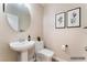 Powder room features pedestal sink, round mirror, and modern decor at 1512 Groom Ave, North Las Vegas, NV 89081