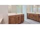 Bathroom with wood cabinets, double sinks, quartz countertops, and a decorative mirror at 157 Sarabeth St, Las Vegas, NV 89138