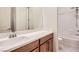 Modern bathroom with a single sink vanity, white countertop, wood cabinets, and a shower tub with tile surround at 157 Sarabeth St, Las Vegas, NV 89138