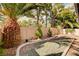 Landscaped backyard featuring gravel ground cover, a palm tree, and a block wall at 1721 Derbyshire Dr, Las Vegas, NV 89117