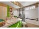 Unique bathroom featuring a green vanity, bright accent wall, and shower-tub combo at 1721 Derbyshire Dr, Las Vegas, NV 89117