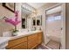 Bright bathroom featuring a tiled vanity, decorative mirror, and separate toilet and shower at 1721 Derbyshire Dr, Las Vegas, NV 89117