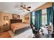 Primary bedroom boasts a king bed, a ceiling fan, and a dedicated workspace with computer at 1721 Derbyshire Dr, Las Vegas, NV 89117