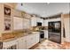 Well-lit kitchen featuring granite countertops and modern stainless steel appliances at 1721 Derbyshire Dr, Las Vegas, NV 89117