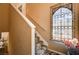 Carpeted staircase with white banister and railing next to a window with decorative ironwork at 1721 Derbyshire Dr, Las Vegas, NV 89117