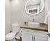 Elegant powder room featuring a vessel sink, marble countertop, and a modern, illuminated mirror at 1808 Michael Ct, Henderson, NV 89014