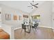 Dining room features light hardwood floors, a ceiling fan, modern artwork, and natural light at 1808 Michael Ct, Henderson, NV 89014