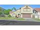 Two-story tan home boasts a well-maintained lawn, a red-tiled roof, and an attached two-car garage at 1808 Michael Ct, Henderson, NV 89014
