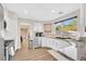 Bright kitchen features white cabinets, stainless steel appliances, marble countertops, and wood-look floors at 1808 Michael Ct, Henderson, NV 89014