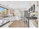 Clean kitchen with white cabinetry, stainless steel appliances, light counter tops, and wood-look floors at 1808 Michael Ct, Henderson, NV 89014