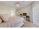 Light-filled bedroom featuring a chandelier, TV, and a comfortable bed with patterned bedding at 2050 W Warm Springs Rd # 224, Henderson, NV 89014