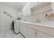 Functional laundry room with white cabinets, countertop space, and modern washer/dryer at 2050 W Warm Springs Rd # 224, Henderson, NV 89014